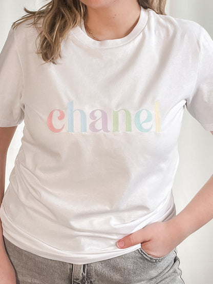 white t-shirt with fruit pastel embroidered design out the purse